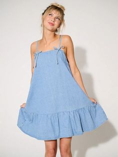 Chic Bow Denim Mini Dress: Your Summer Style Essential Summer Mini Dress With Tie Back For Casual Wear, Cotton Mini Dress With Tie Straps For Brunch, Spring Trendy Dresses With Tie Straps, Summer Mini Dresses With Bow Straps, Trendy Spring Dresses With Tie Straps, Trendy Summer Mini Dress With Tie Straps, Chic Cotton Mini Dress With Tie Fastening, Day Out Mini Dress With Tie Fastening, Cotton Mini Sundress With Tie Straps