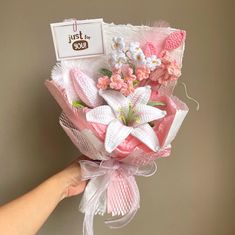 a hand holding a bouquet of pink and white flowers