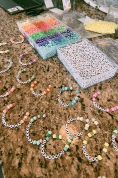 many beads and bracelets are laid out on the counter top next to each other