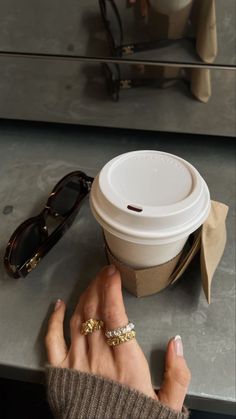 a woman's hand holding onto a coffee cup