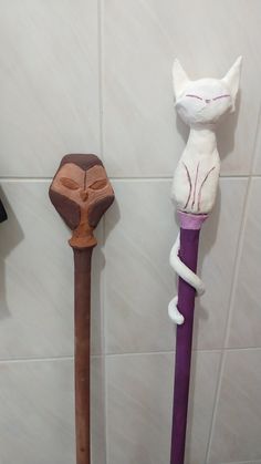 three different types of decorative items on the wall next to each other, one with a cat's head and another with a snake's tail