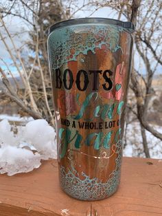 a cup that is sitting on top of a piece of wood with the words boots and a whole lot of snow