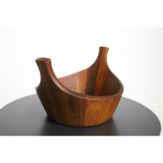 a wooden bowl sitting on top of a black table