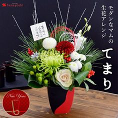 a vase filled with lots of flowers on top of a wooden table next to a blackboard