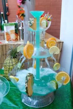 there is a water fountain made out of oranges and pineapples on the table