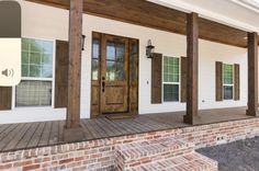 the front porch of a house with wooden doors and windows