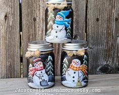 three jars with snowmen painted on them