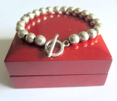 Here we have a superb sterling silver ball bead bracelet that was probably made in the 90s. It is quite heavy weighing 27 grams and the silver ball beads are 8mm wide and thread onto a silver chain.. The bracelet has been finished using a large 14mm diam toggle clasp that is hallmarked sterling and also includes a British Assay Hallmark showing 925 purity. Also, this quality bracelet was made in Mexico.       Bracelet Length 8.5" Inches By 8mm Wide - Stamped Sterling 925 & Mexico Also British Ha Silver Pieces, Toggle Clasp, Bead Bracelet, Hallmark, Jewelry Pieces, My Jewellery, Silver Chain, Jewelry Bracelets, Thread