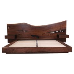 a wooden bed frame with white sheets and headboard