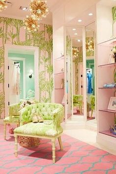 a pink and green room with palm trees on the wall, chandelier, chair, and mirror