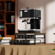 an espresso machine sitting on top of a table next to a stack of books