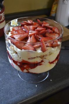 a dessert with strawberries and cream in a glass dish