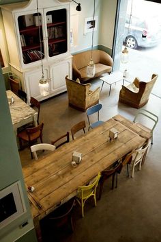 an overhead view of a living room and dining area with chairs, tables, and bookshelves