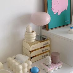 a pink pig lamp sitting on top of a table next to other toys and decor