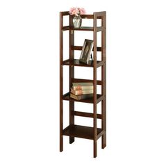 a wooden shelf with books and flowers on top