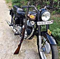 a black motorcycle parked on top of a dirt road