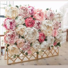 a bunch of flowers that are sitting on a stand in front of a window,