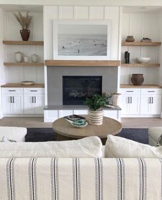 a living room with two couches and a coffee table in front of the fireplace