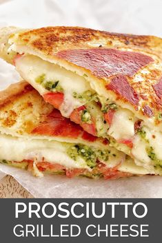 a grilled cheese sandwich with broccoli and tomatoes on it is cut in half