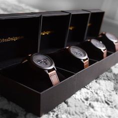 three watches are sitting in a black box