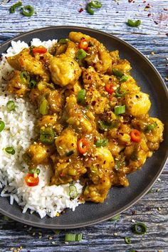 a black plate topped with rice and chicken