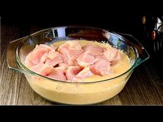 a glass bowl filled with food on top of a wooden table