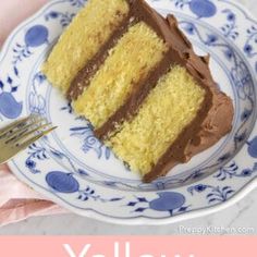 a piece of yellow cake with chocolate frosting on a blue and white plate next to a fork