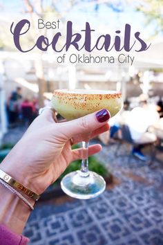 a hand holding a wine glass with the words best cocktails of oklahoma city