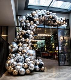 a bunch of silver and black balloons in front of a building