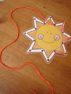 a star shaped kite with a smiling face on it's side sitting on a wooden floor