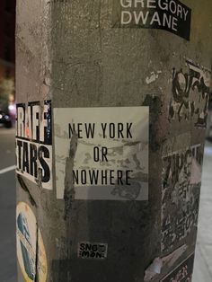 stickers and decals on the side of a street pole in new york city