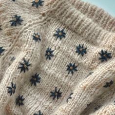 a knitted sweater with blue stars on the front and back, sitting on top of a table