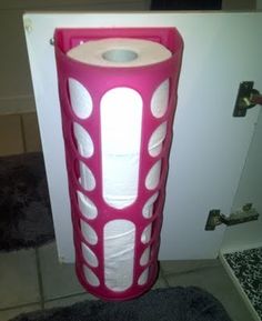 a pink toilet paper holder with white circles on it