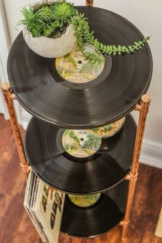 an old record player turned into a planter with vinyl records on the bottom shelf