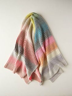 a multicolored scarf laying on top of a white table