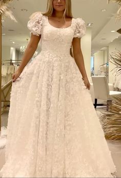 a woman in a white wedding dress posing for the camera