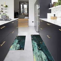 a kitchen with marble counter tops and flooring that looks like an abstract painting on the wall