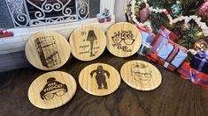 four wooden coasters with cartoon characters on them next to a christmas tree and presents