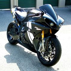 a black motorcycle parked in front of a garage