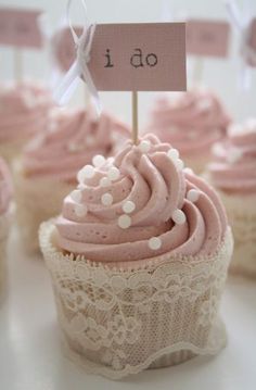 cupcakes with pink frosting and white polka dots are on display for the guests to eat