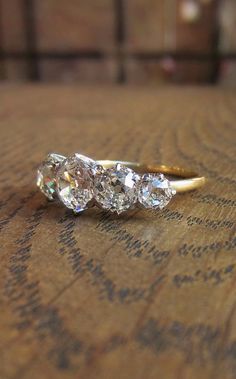 three diamond rings sitting on top of a wooden table