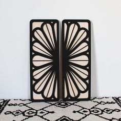 two black and white art deco bookends sitting on top of a rug