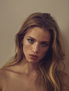 a young woman with freckled hair and blue eyes is posing for the camera