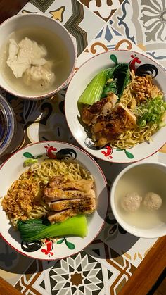 three plates filled with food on top of a table next to bowls and spoons