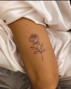 a single rose tattoo on the arm