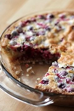 a pie sitting on top of a wooden table next to a slice missing from it