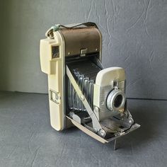 an old fashioned camera sitting on top of a table