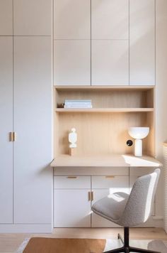 a white chair sitting in front of a desk with a book shelf on top of it