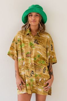 Vintage x Resurrection Hawaiiana Oversized Button Shirt features a retro Hawaiian design with button down front and chest pocket. Color: Gold/Green Multi Oversized Fit Short Sleeve Silk Brand: Creations Mens Size Large There will be imperfections and flaws that make this jacket unique in character with no two alike. There are some minor tears. These are not defects and simply lend to the character of this extra special piece. VINTAGE - FINAL SALE ITEM Retro Collared Hawaiian Shirt With Relaxed Fit, Retro Relaxed Fit Collared Hawaiian Shirt, Vintage Oversized Shirt With Pockets, Vintage Green Hawaiian Shirt Relaxed Fit, Vintage Beach Camp Shirt With Relaxed Fit, Vintage Camp Shirt For Beach In Relaxed Fit, Vintage Relaxed Fit Shirt For Vacation, Retro Button-up Hawaiian Shirt, Retro Hawaiian Shirt With Relaxed Fit