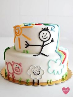 a white cake with colorful frosting and cartoon characters on it's icing